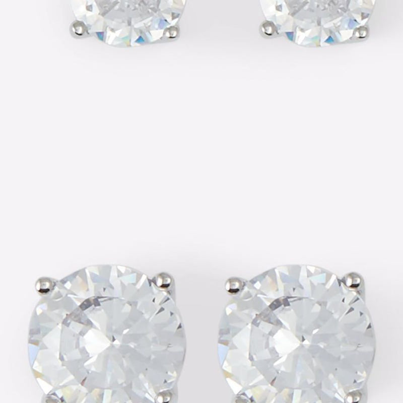 Silver stud earrings featuring large round faceted clear stones in prong settings