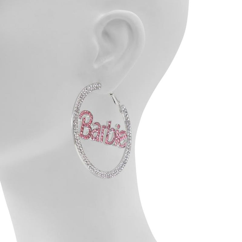 Large silver rhinestone hoop earrings featuring the pink Barbie logo across the center