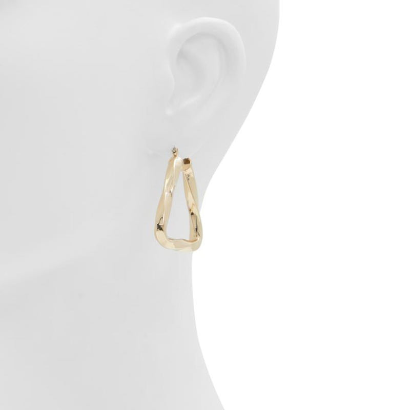 Gold twisted metal geometric hoop earrings worn on a mannequin ear