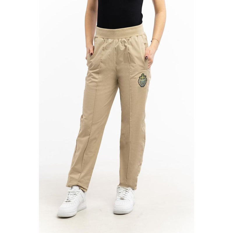 Beige cotton joggers with an elastic waistband and a patch on the left leg