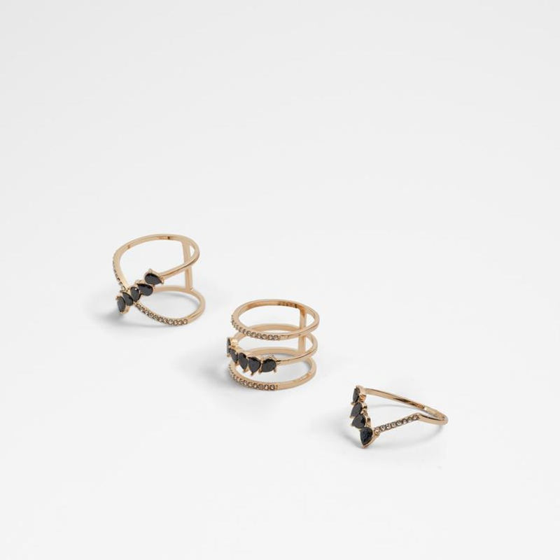 Three gold-tone metal rings adorned with black teardrop stones and small crystals