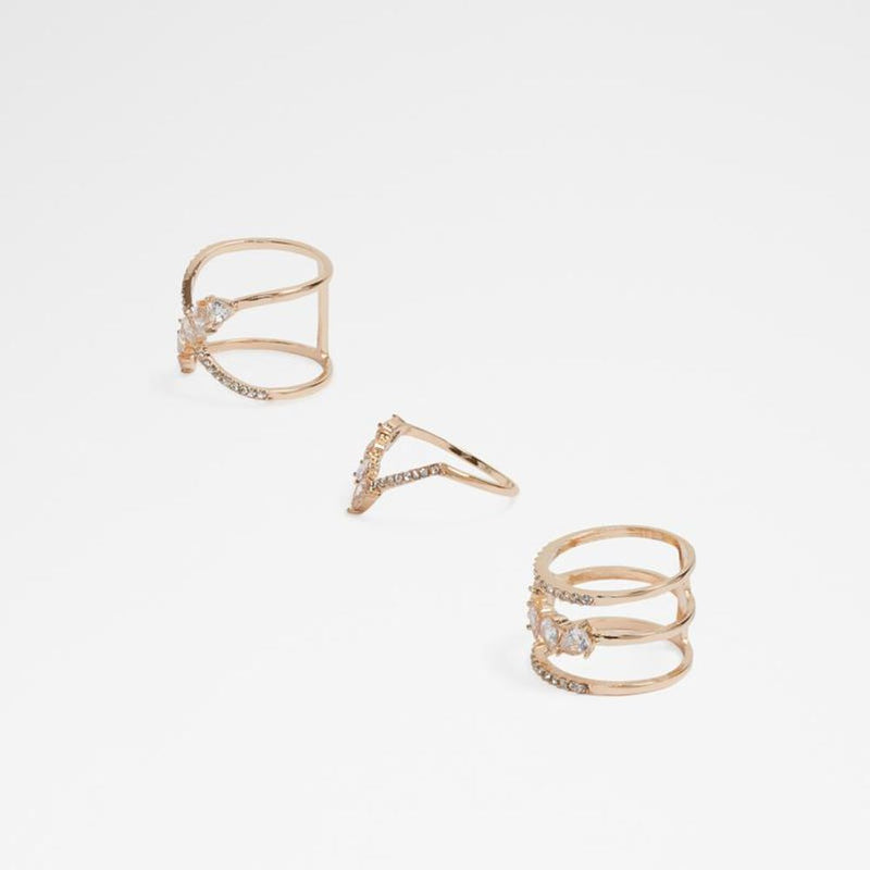Set of gold multi-band rings with sparkling crystal embellishments against a plain background