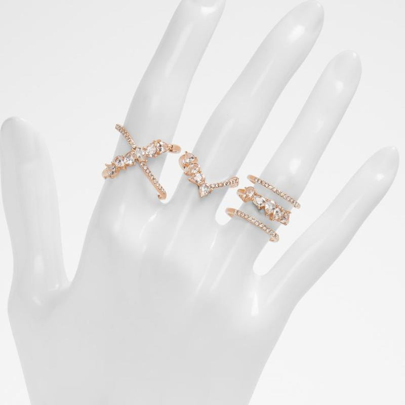 A set of gold rhinestone rings worn on a white mannequin hand