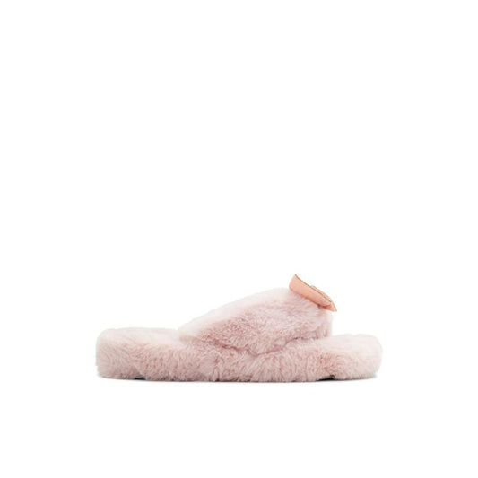 Female model wearing Jil Sander blush pink fluffy shearling thong sandal with an ultra-plush shearling upper, delicate rose gold bow accent, and cushioned shearling platform sole, captured mid-step in a casual lifestyle pose showcasing the sandal's cosy feminine luxury and effortless designer comfort.