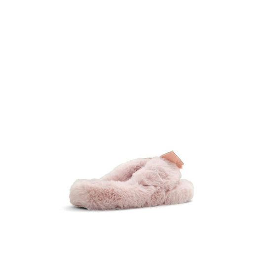 Female model wearing Jil Sander blush pink fluffy shearling thong sandal with an ultra-plush shearling upper, delicate rose gold bow accent, and cushioned shearling platform sole, captured mid-step in a casual lifestyle pose showcasing the sandal's cosy feminine luxury and effortless designer comfort.