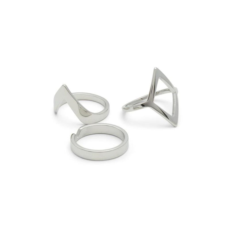Three modern silver metal rings in geometric shapes including a triangle, chevron, and band