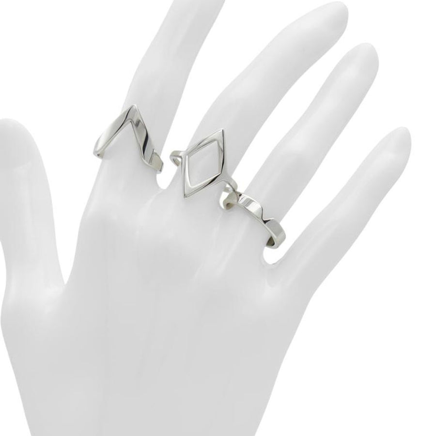 Three modern silver metal rings in geometric shapes including a triangle, chevron, and band