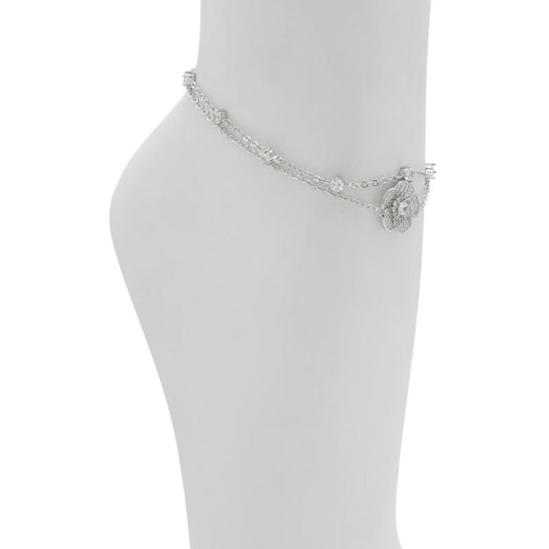 Silver metal double-strand anklet with crystal accents and a flower charm worn on an ankle