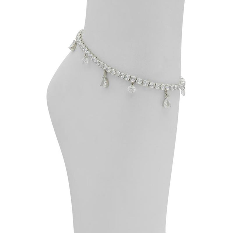 Silver rhinestone anklet with dangling teardrop charms worn around an ankle