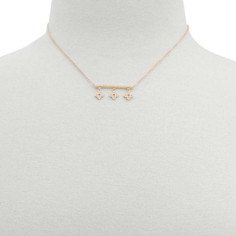 Gold metal chain necklace with a horizontal bar and three small clover charms centered on a mannequin
