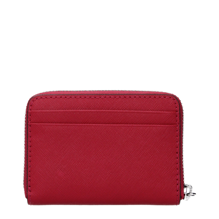 Red textured leather cardholder with a top zipper and silver Michael Kors logo on the front