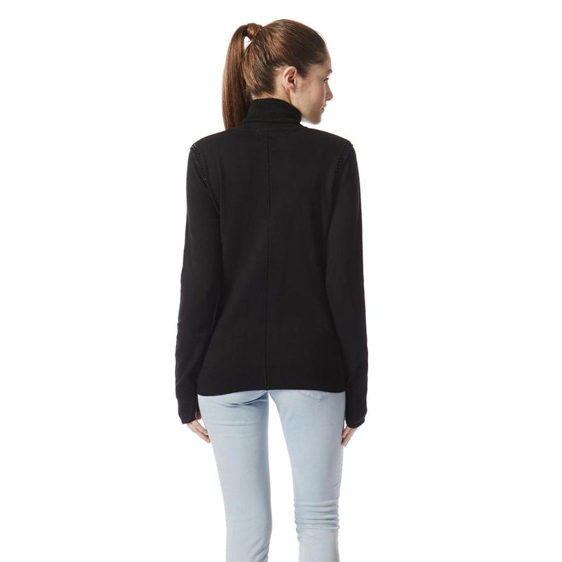 Back view of a woman wearing a black cotton turtleneck sweater and light blue jeans