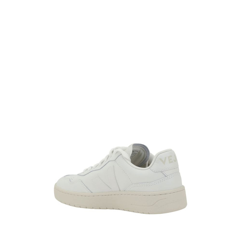 White low top synthetic leather sneaker with flat laces and cream rubber sole