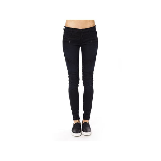Dark blue cotton skinny pants with zipped pockets and paneled knees worn with black slip-on shoes