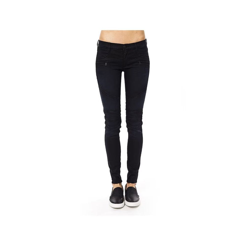 Dark blue cotton skinny pants with zipped pockets and paneled knees worn with black slip-on shoes