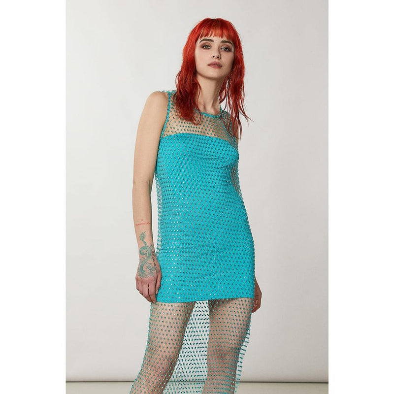 Model wearing a turquoise crystal-embellished mesh overlay dress over a matching mini dress