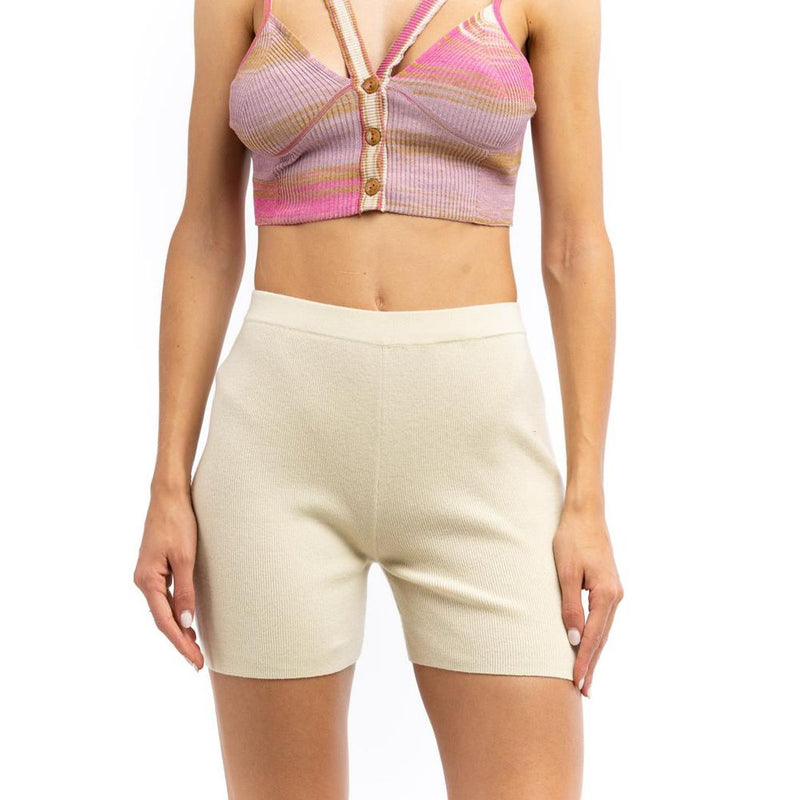 Beige ribbed knit nylon shorts worn with a pink striped crop top