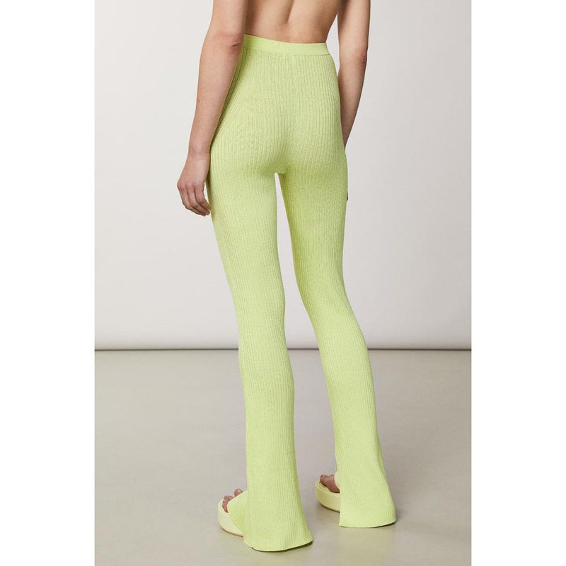 Back view of bright yellow ribbed knit viscose casual pants on a model