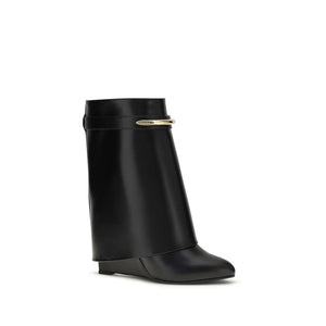 Black calf leather ankle boot with wide cuff, hidden wedge heel, and gold-tone Givenchy metal bar detail.