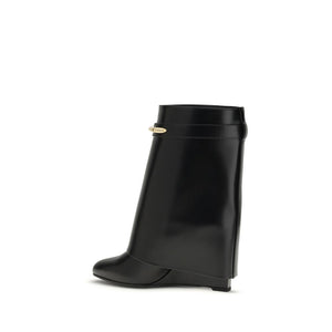 Givenchy black calf leather wedge ankle boot with a rounded toe and a gold-tone metallic logo hardware strap detail.