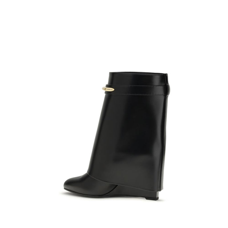 Givenchy black calf leather wedge ankle boot with a rounded toe and a gold-tone metallic logo hardware strap detail.