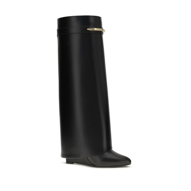 Black Givenchy Shark Lock leather knee-high boot with a wedge heel and gold-tone metal band accent.