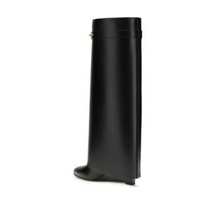 Black knee-high leather boot with a wide shaft, structured silhouette, and a small wedge heel.
