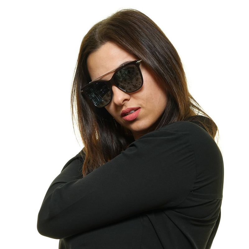 Woman wearing brown metal and plastic aviator sunglasses with tinted lenses