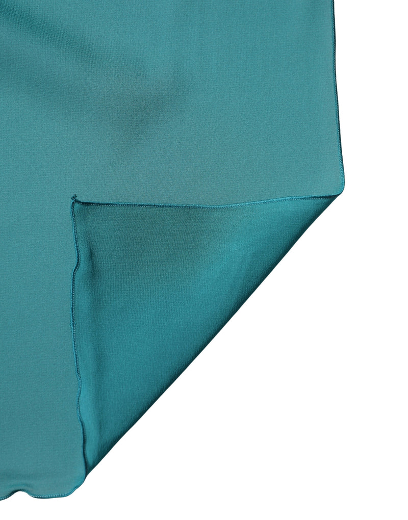 Teal blue-green silk scarf showing folded edge and fine texture