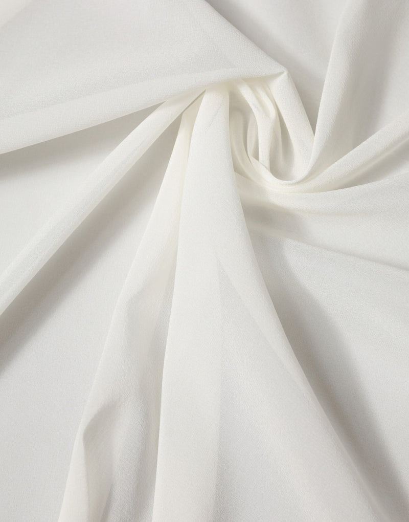Off white silk scarf draped gracefully, showing soft, flowing fabric texture