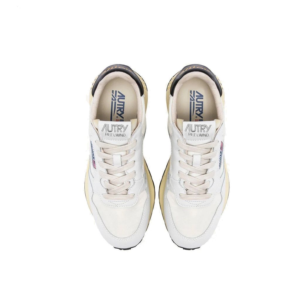 Top-down view of Autry white fabric athletic sneakers with lace-up closure, branded tongues, and navy heel accents.