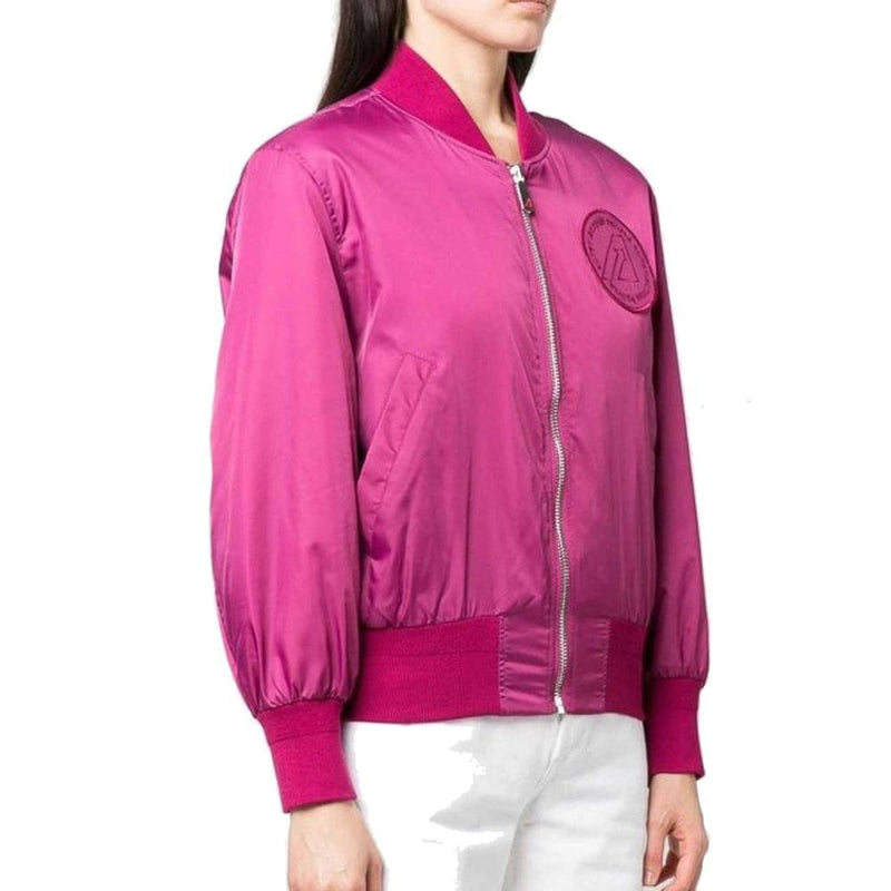 Bright magenta nylon bomber jacket with zip front and round chest patch worn with white pants