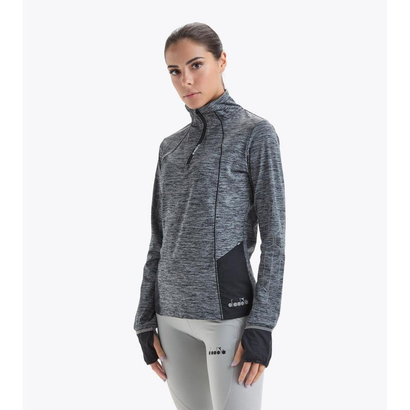 Black polyester athletic sweatshirt with long sleeves, high neck, and half-zip closure worn by a woman
