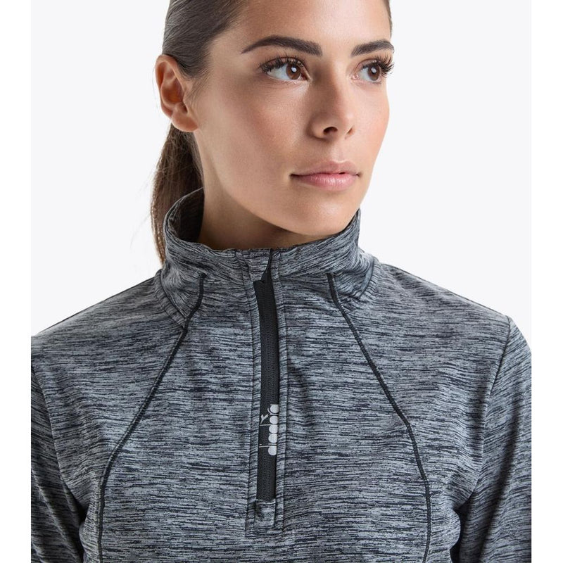 Woman wearing a black and grey heathered polyester quarter zip sweatshirt with a high collar
