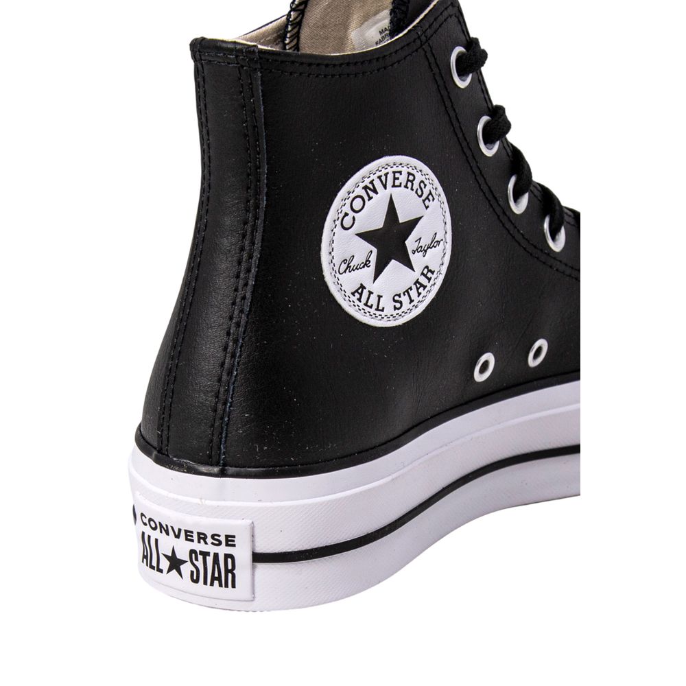 Close-up of a black leather Converse Chuck Taylor high-top sneaker with white sole and iconic circular patch logo.
