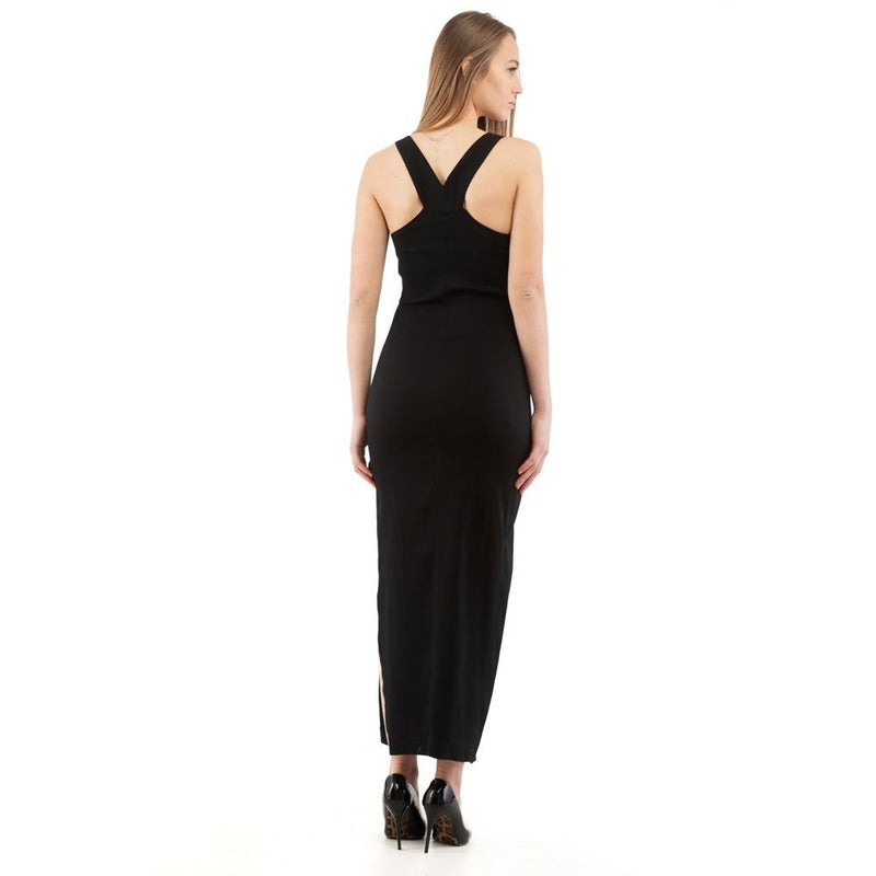 Woman wearing a black sleeveless maxi dress with a crisscross back strap and side slit