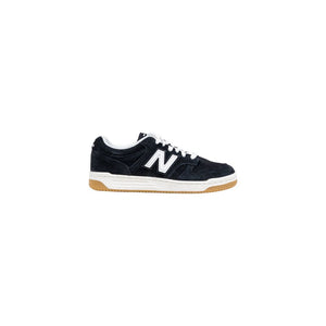 New Balance black suede low-top sneaker with white "N" logo, white laces, and gum rubber outsole.