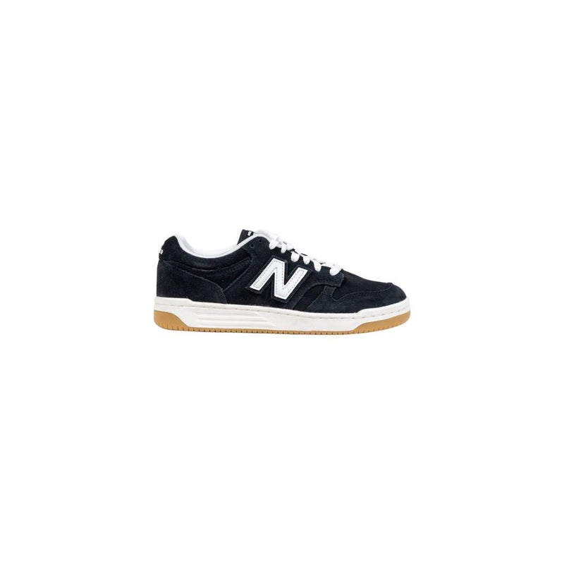 New Balance black suede low-top sneaker with white "N" logo, white laces, and gum rubber outsole.
