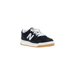 New Balance low-top athletic sneaker in black suede with white leather 'N' logo, white laces, and gum rubber outsole.