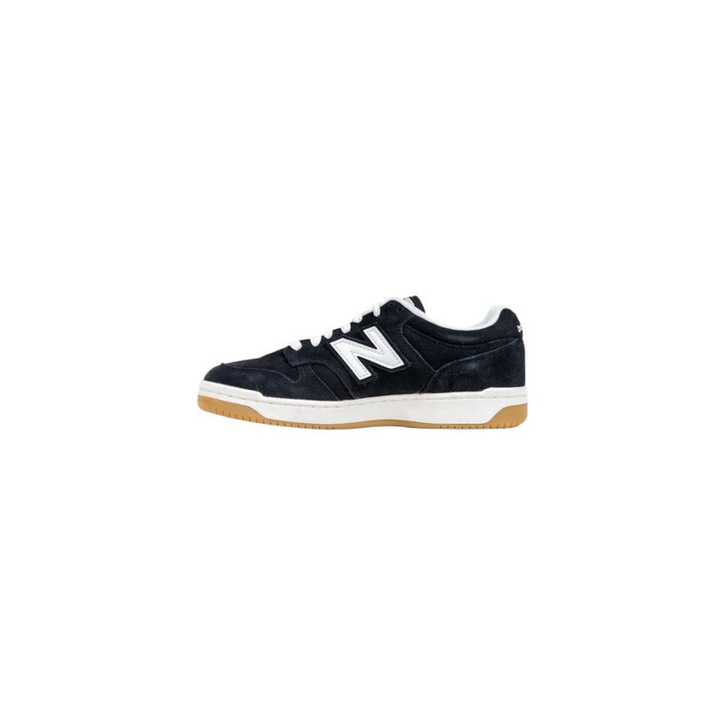 New Balance black suede and white leather athletic sneaker with white laces and a tan rubber gum sole.