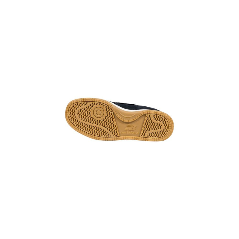 Black and white New Balance athletic sneaker with a textured gum rubber outsole featuring a circular tread pattern.