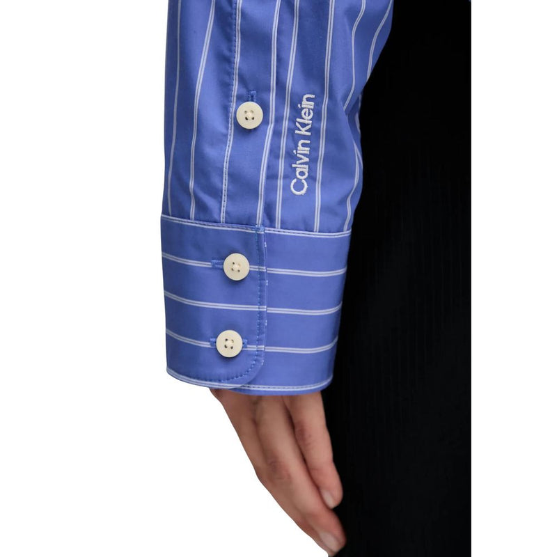 Blue cotton blouse sleeve with white vertical stripes and Calvin Klein logo embroidered near the button cuff
