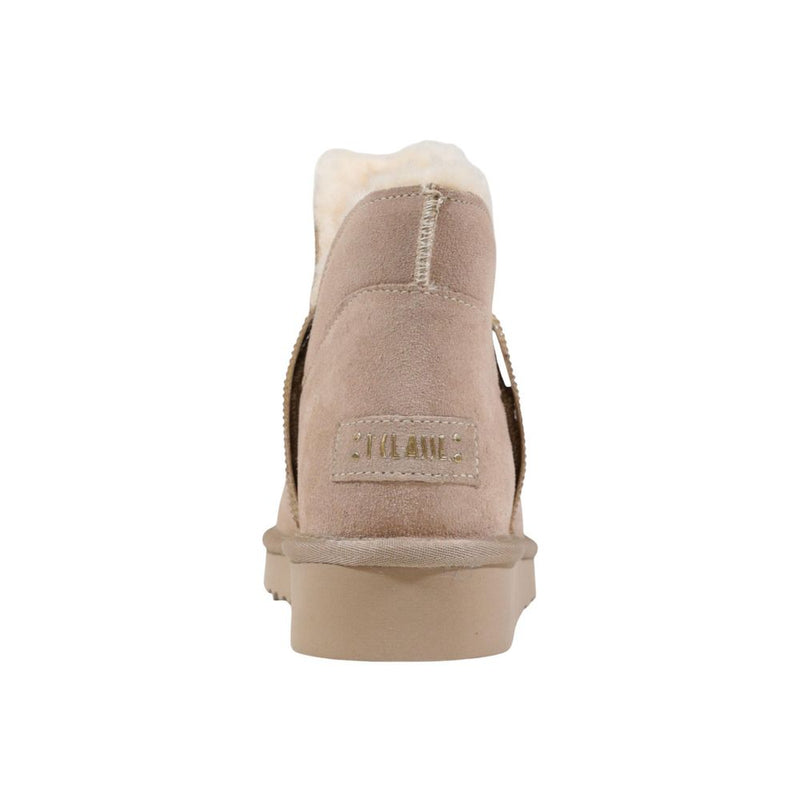 Beige suede ankle boots with cream faux fur lining and gold embossed branding on the heel, set on a flat rubber sole.