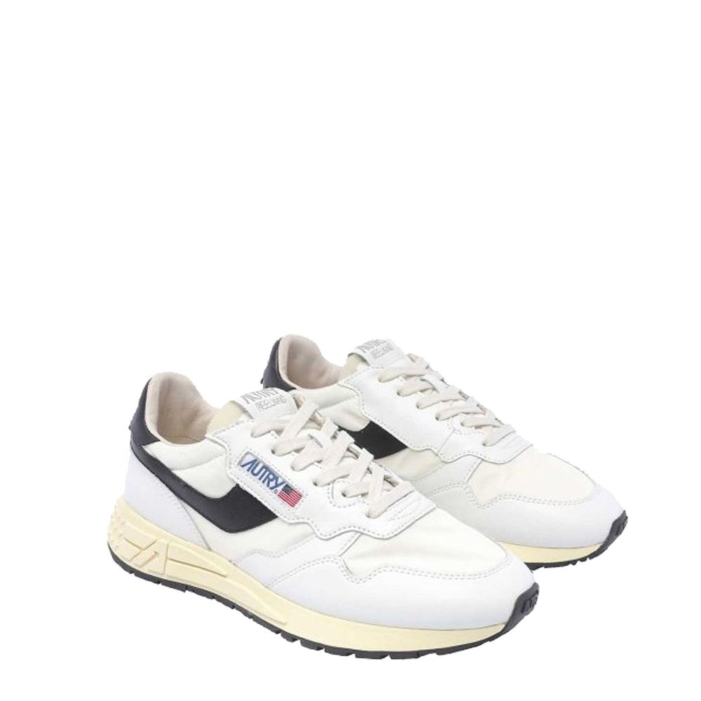 Autry low-top sneakers in white leather with black side accents, off-white midsole, and lace-up front.