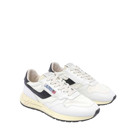 Autry low-top sneakers in white leather with black side accents, off-white midsole, and lace-up front.