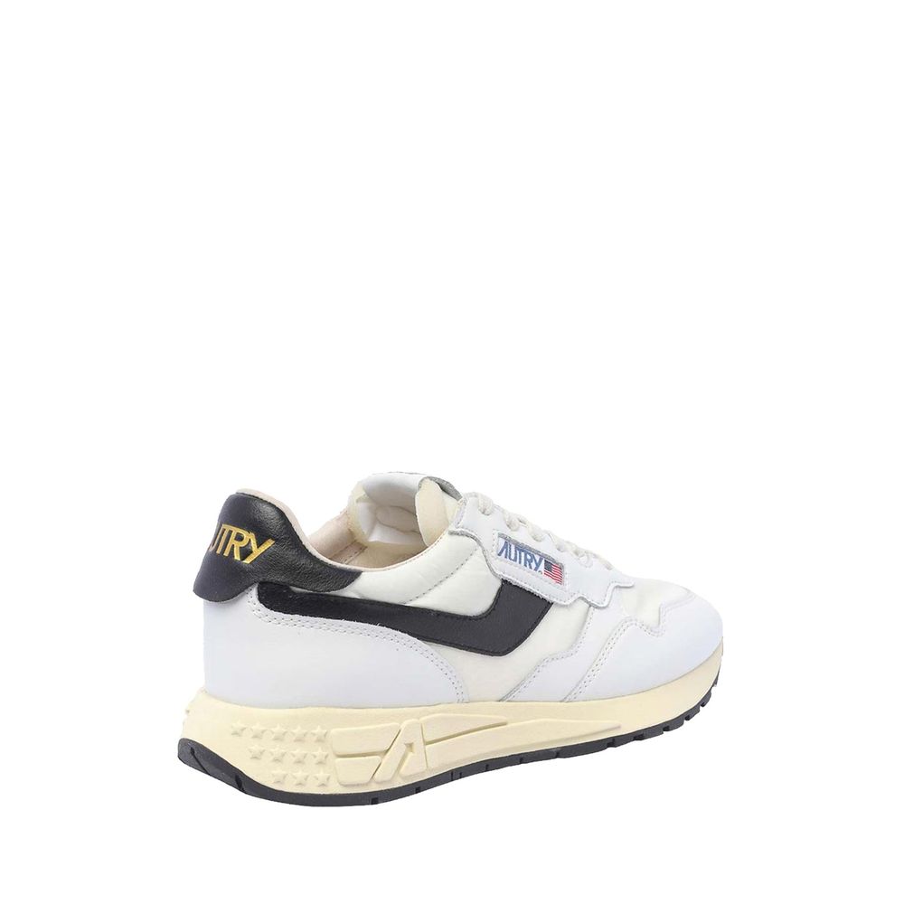 Autry low-top sneakers in white leather with black side stripes, heel tab, and aged-effect cream rubber sole.