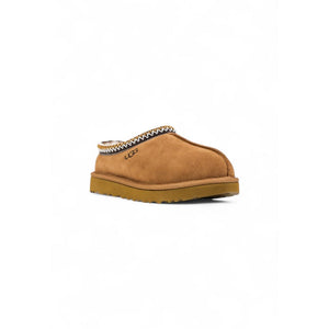 UGG beige suede slip-on shoe with decorative braided collar trim and thick rubber sole.