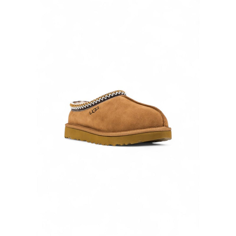 UGG beige suede slip-on shoe with decorative braided collar trim and thick rubber sole.