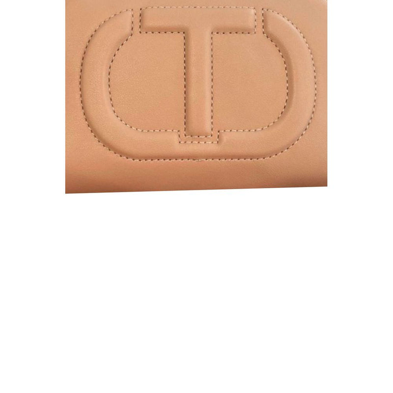 Close-up of pink faux leather crossbody bag with debossed T logo