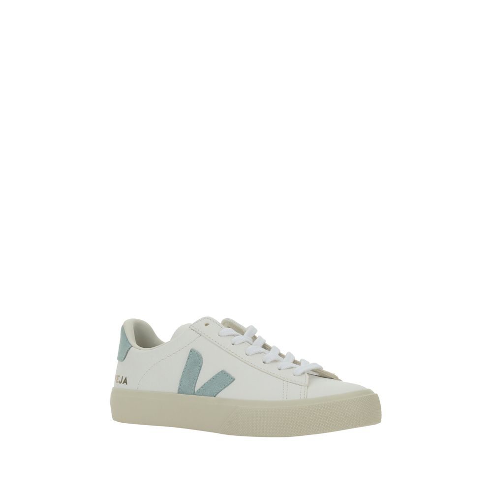 White leather Veja low-top sneakers with light blue suede V logo and heel tab, plus a textured beige rubber sole.